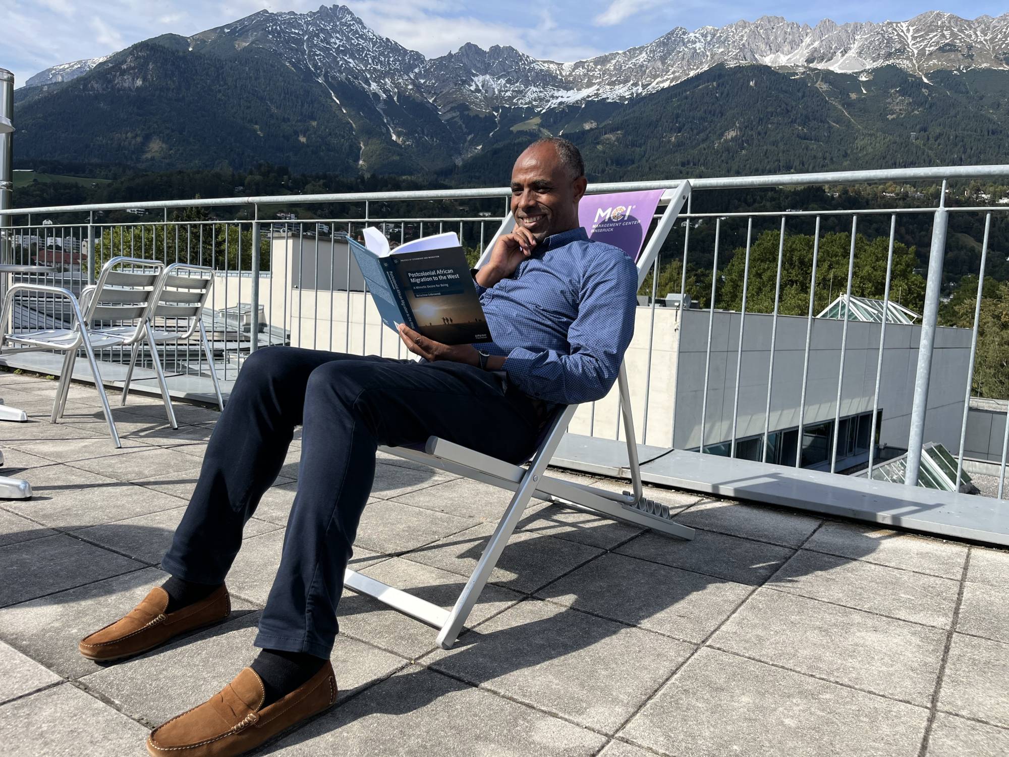 <p>Belachew Gebrewold with his book “Postcolonial African Migration to the West: A Mimetic Desire for Being” © MCI/Verena Schmid</p>