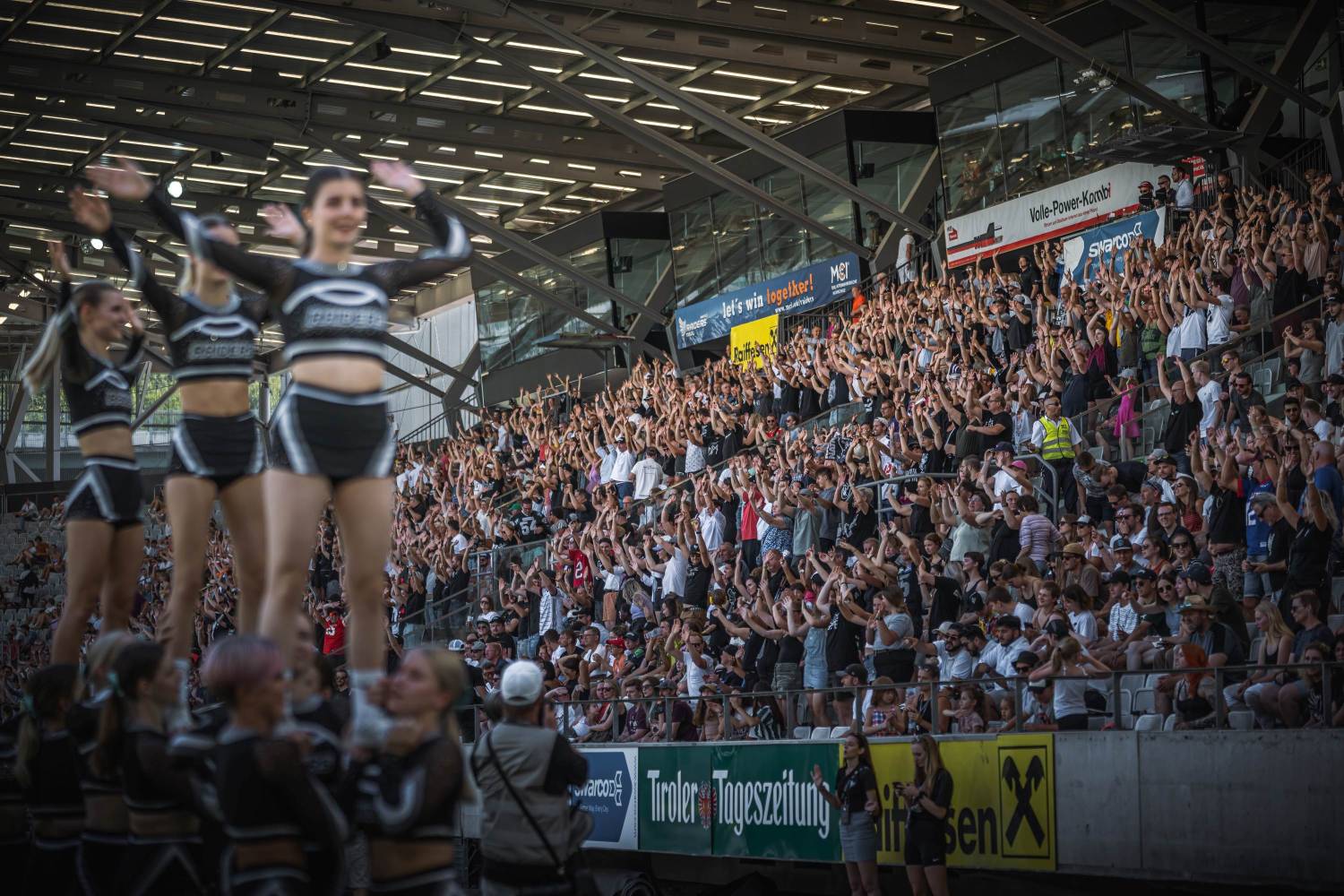 Cheerleaders and audience at Tivoli Stadium Innsbruck at a home game of Swarco Raiders Tirol.